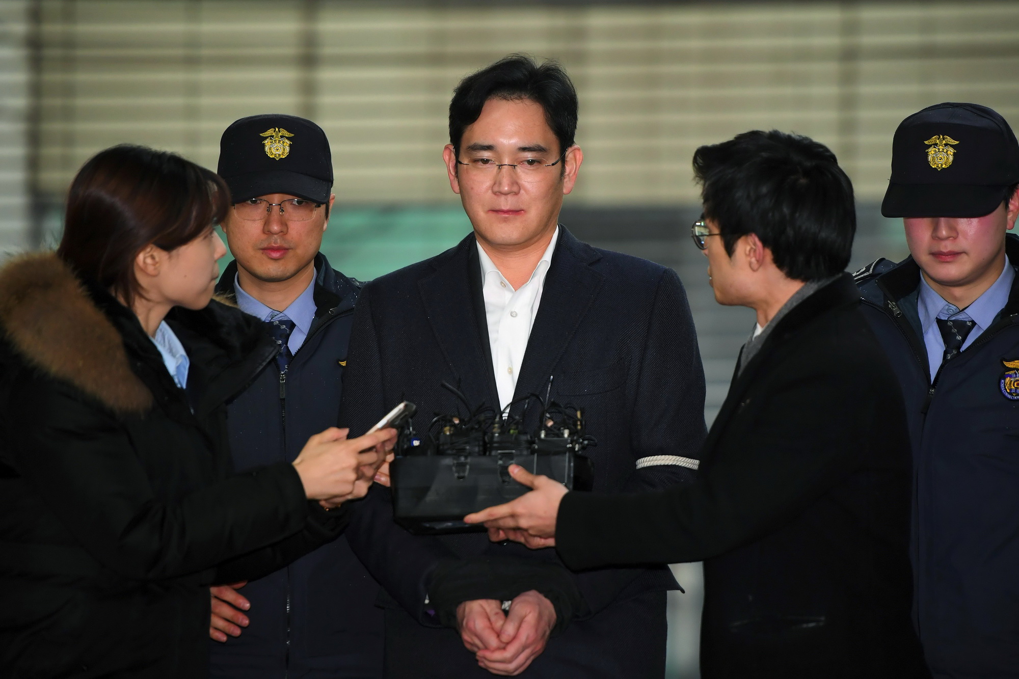 Lãnh đạo Tập đoàn Samsung Lee Jae-yong (giữa) tới Văn phòng công tố ở Seoul để trả lời thẩm vấn ngày 22/2. (Ảnh: AFP/TTXVN)