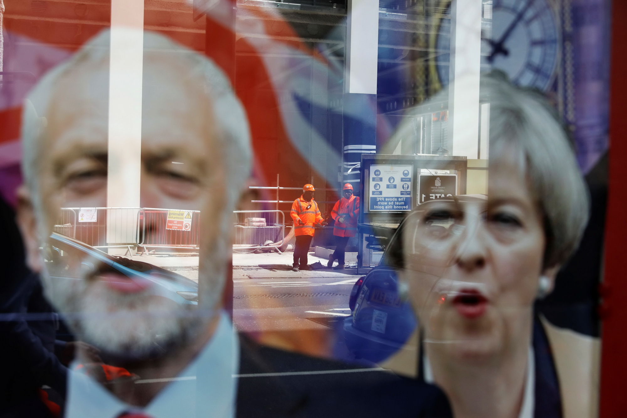 Công nhân làm việc tại một khu vực mà trên cửa có hình ảnh  của Thủ lĩnh Công Đảng Jeremy Corbyn và Thủ tướng Anh Theresa May.(Nguồn: Reuters)