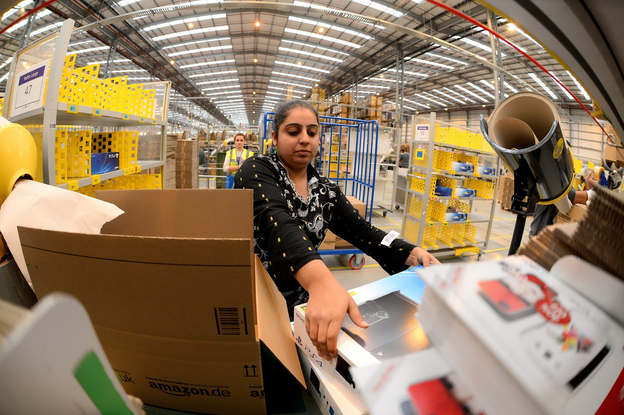 Công nhân làm việc tại một trung tâm của tập đoàn Amazon ở Peterborough, Anh. (Nguồn: AFP/TTXVN)