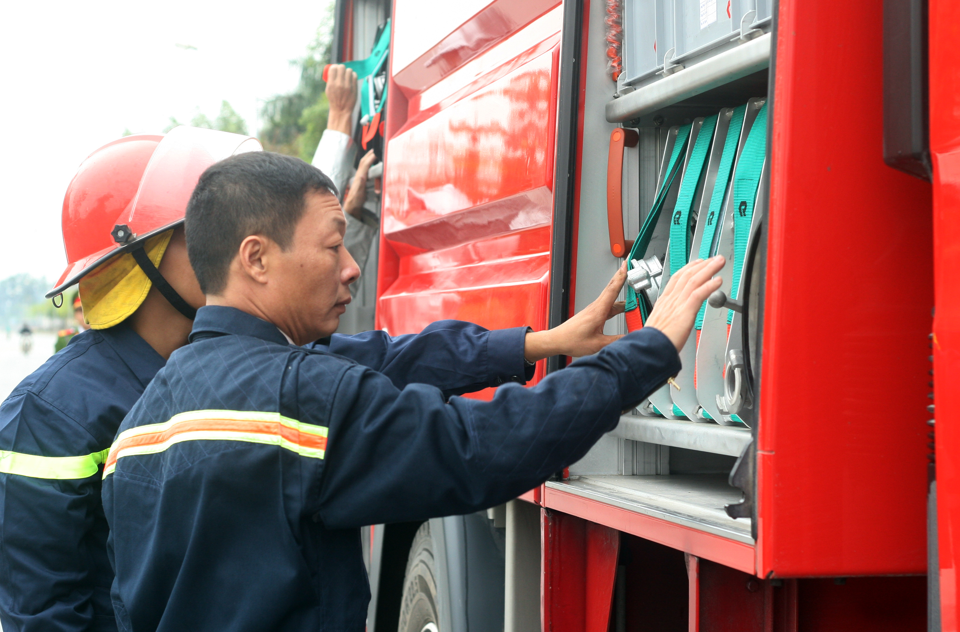 Thượng tá Đỗ Anh Quyến (phải) kiểm tra thiết bị trên xe cứu hỏa. (Ảnh: T.H/Vietnam+)