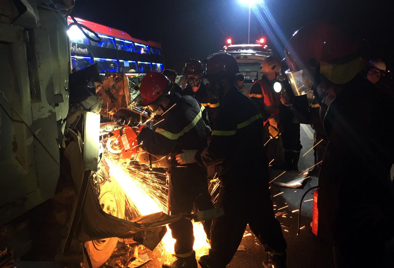 Lính cứu hỏa phá xe tai nạn, đưa người bị nạn ra ngoài. (Ảnh: CTV/Vietnam+)