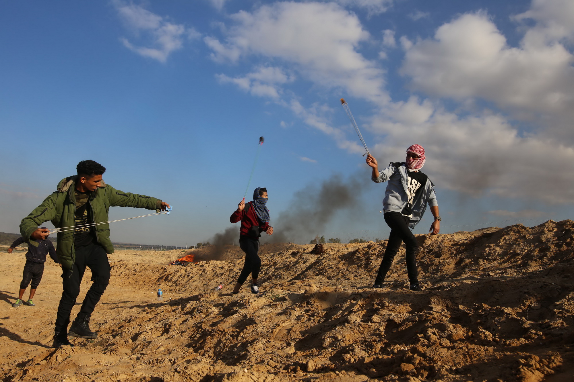 Người biểu tình Palestine ném đá vào  binh sỹ Israel  tại Dải Gaza ngày 8/12. (Nguồn: THX/TTXVN)