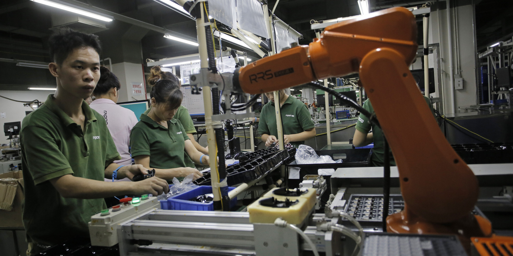 Công nhân và robot cùng làm việc tại một nhà máy ở Trung Quốc. (Nguồn: Huffingtonpost)
