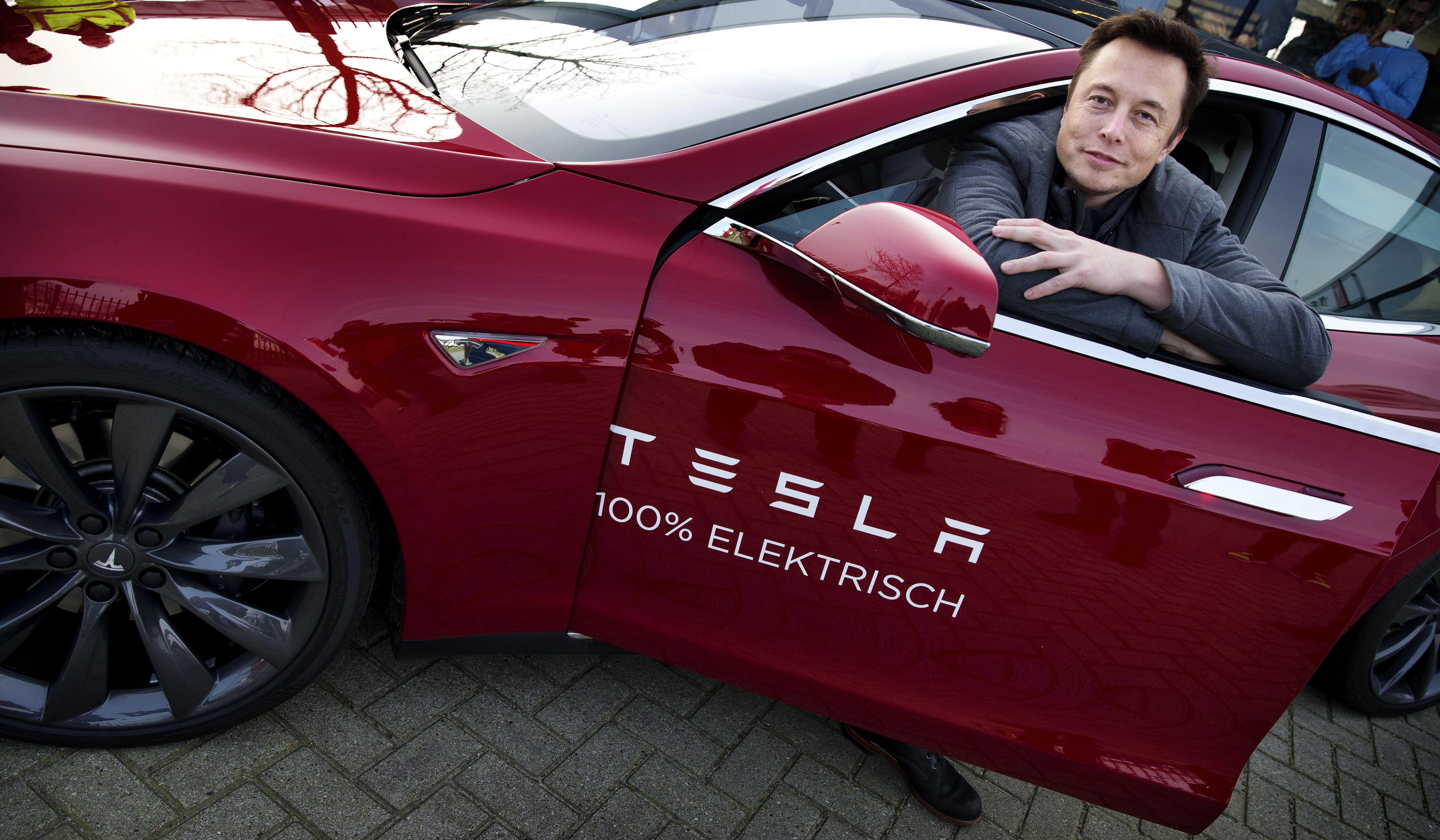 Elon Musk với chiếc xe ôtô điện của hãng Tesla. (Nguồn: AFP)