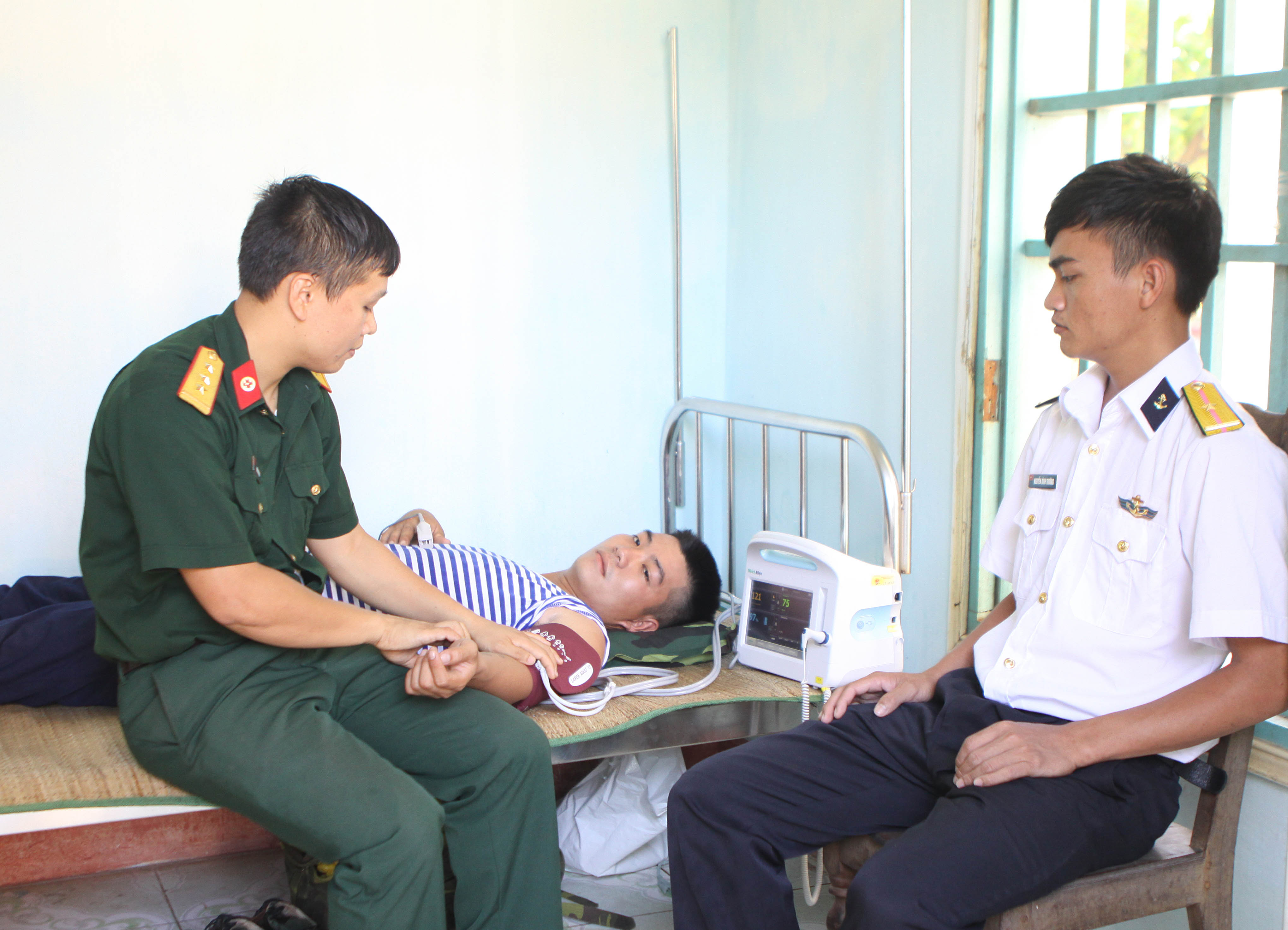  Các chiến sỹ quân y đảo Sơn Ca khám chữa bệnh cho cán bộ chiến sỹ. (Ảnh: Dương Giang/TTXVN)