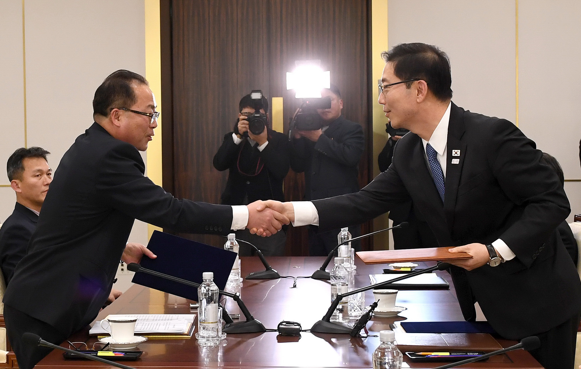 Trưởng đoàn đàm phán của Hàn Quốc, Thứ trưởng Bộ Thống nhất Chun Hae-sung (phải) và Trưởng đại diện đàm phán của Triều Tiên, Phó Chủ tịch Ủy ban tái thống nhất hòa bình Jon Jong Su (trái, phía trước) trao đổi văn kiện tại cuộc đàm phán ở làng đình chiến Panmunjom ngày 17/1. (Nguồn: THX/TTXVN)
