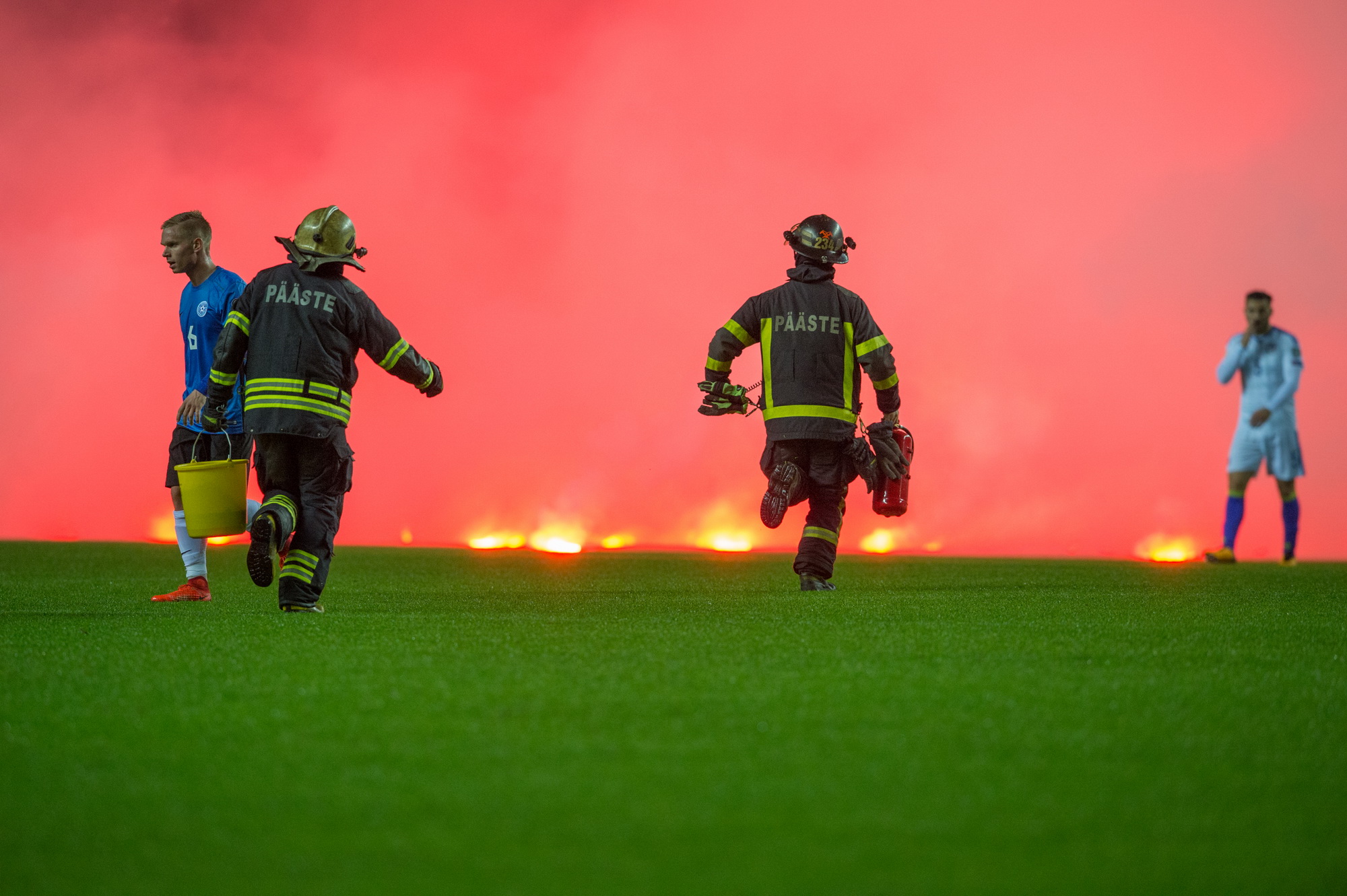 Nhân viên cứu hỏa là những người vất vả nhất khi pháo sáng được ném xuống sân (Nguồn: AFP)