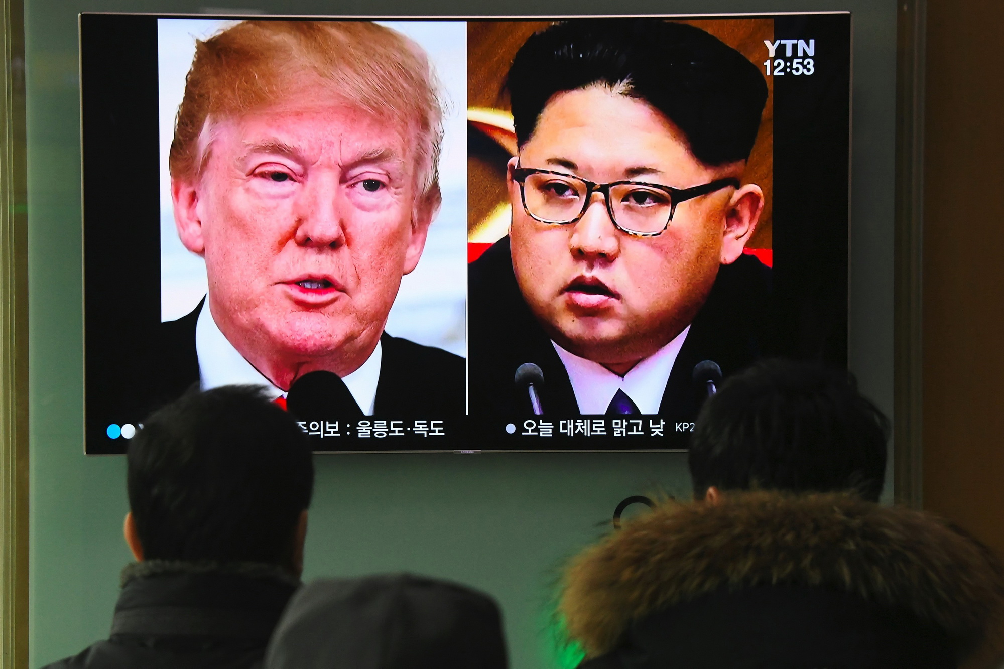 Người dân theo dõi hình ảnh Tổng thống Mỹ Donald Trump  (trái) và nhà lãnh đạo Triều Tiên Kim Jong-un trên truyền hình ở Seoul  (Hàn Quốc) khi truyền thông đưa tin về khả năng diễn ra cuộc gặp lịch sử  Mỹ-Triều. (Nguồn: AFP/TTXVN)