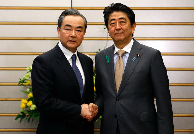 Bộ trưởng Ngoại giao Trung Quốc Vương Nghị và Thủ tướng Nhật Bản Shinzo Abe. (Nguồn: AP)