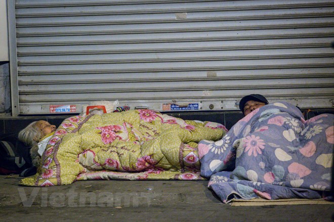 Đâu đó trên những hè phố cổ có những người vô gia cư, mặc giá rét của mùa đông mà nằm ngủ. (Ảnh: Minh Sơn/Vietnam+)