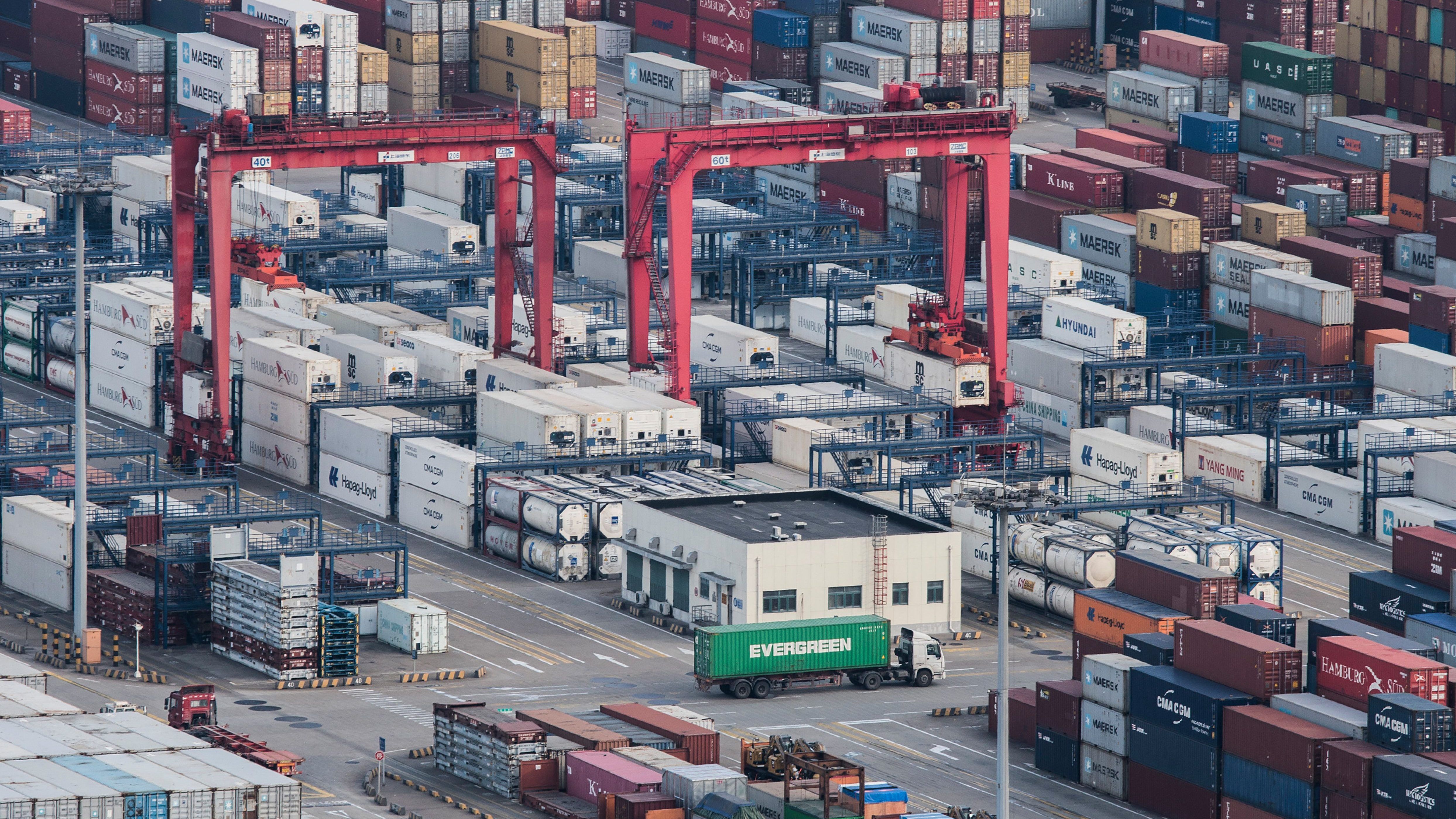 Một chiếc xe tải chở hàng chạy giữa các container vận chuyển xếp chồng lên nhau tại cảng Yangshan ở Thượng Hải (Trung Quốc). (Nguồn: AP)
