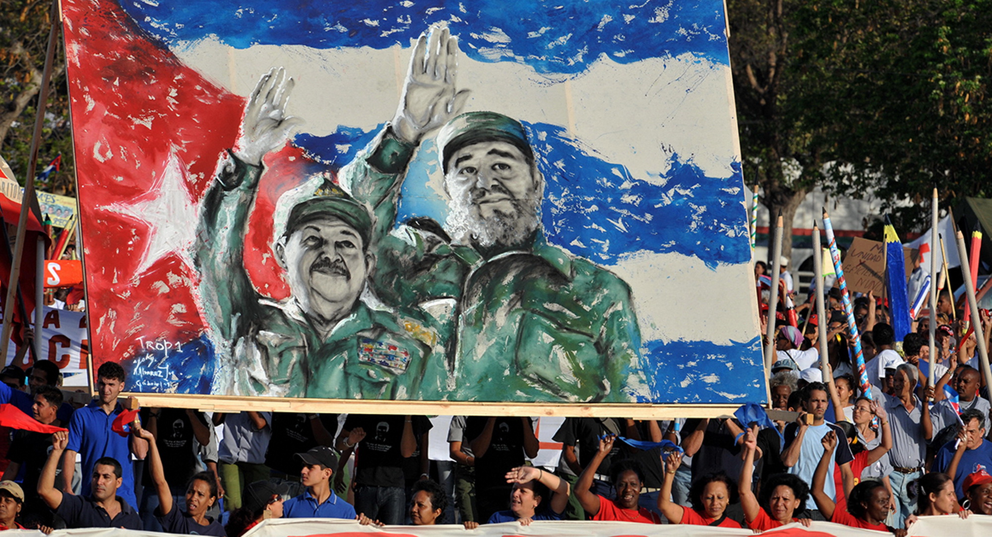 Người dân tuần hành ngày kỷ niệm Quốc tế Lao động 1/5 với hình ảnh anh em nhà lãnh đạo Fidel và Raul Castro. (Nguồn: AFP)