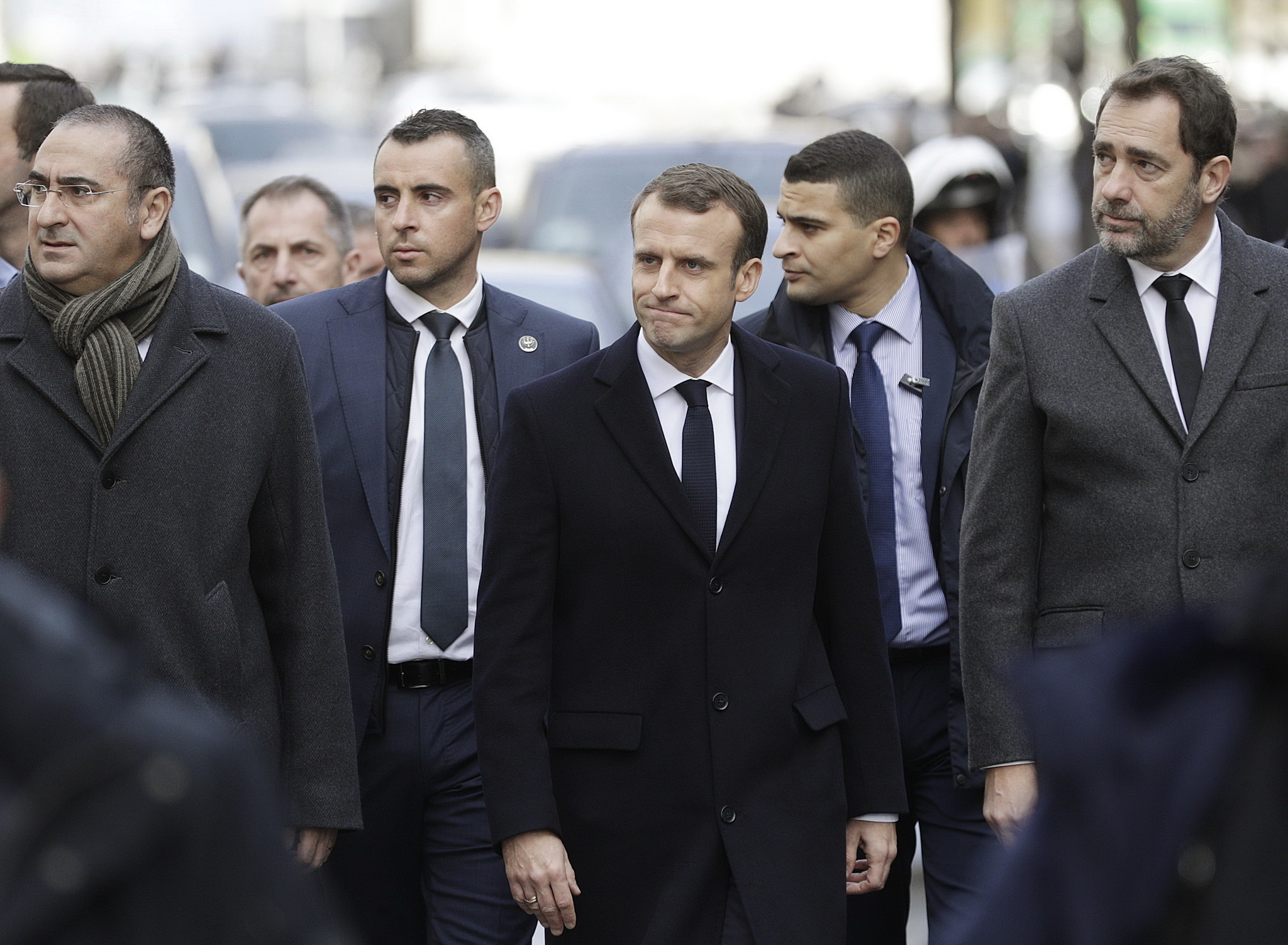 Tổng thống Pháp Emmanuel Macron (giữa, phía trước) và các quan chức Chính phủ thị sát một tuyến phố ở thủ đô Paris, nơi nổ ra các cuộc biểu tình bạo loạn của lực lượng 'Áo vàng' nhằm phản đối tăng giá nhiên liệu. (Ảnh: AFP/TTXVN)