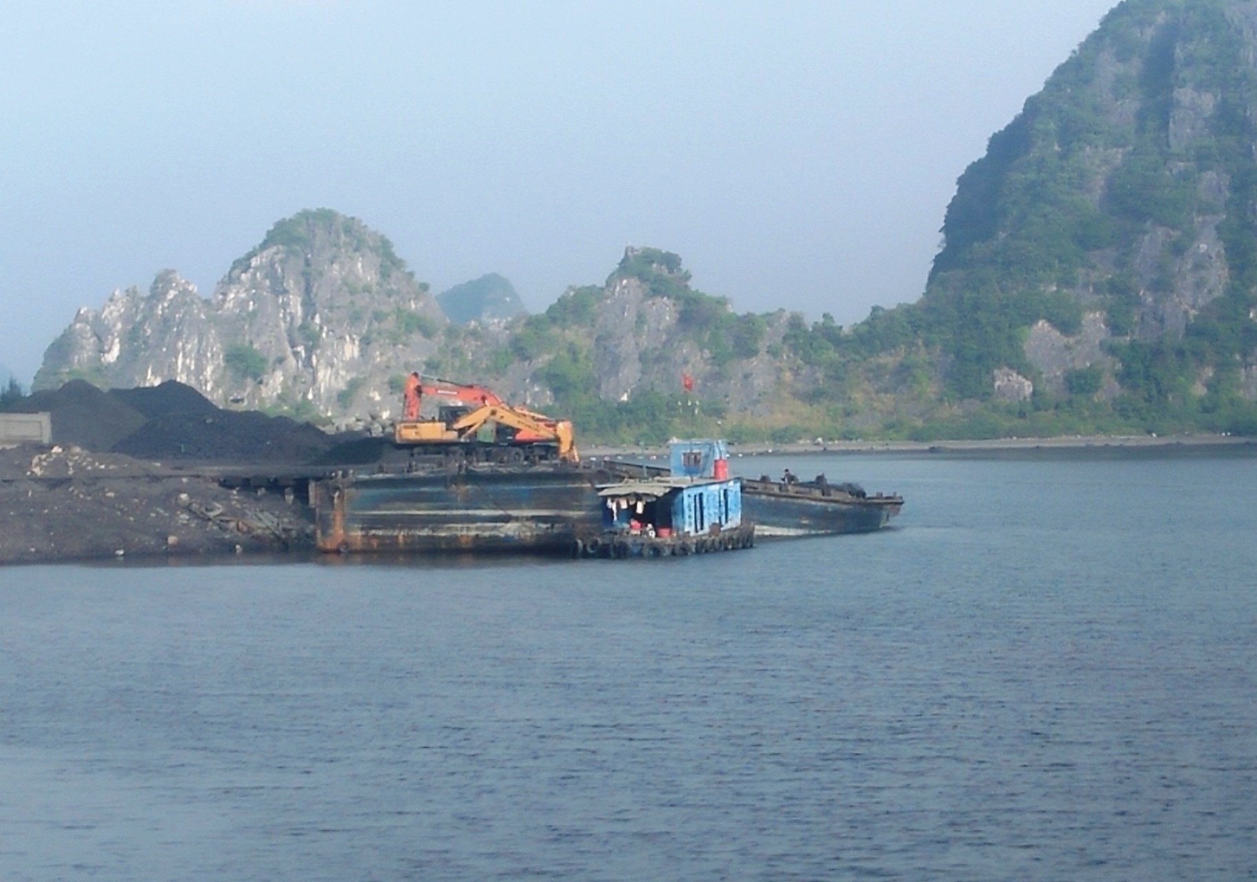 Hai chiếc máy cẩu bốc xít, than lên những chiếc xà lan và tàu hơn nghìn tấn mang số hiệu ở các tỉnh Hải Dương, Nam Định, Thái Bình chở đi tiêu thụ bằng tàu biển. (Ảnh: P.V/Vietnam+)