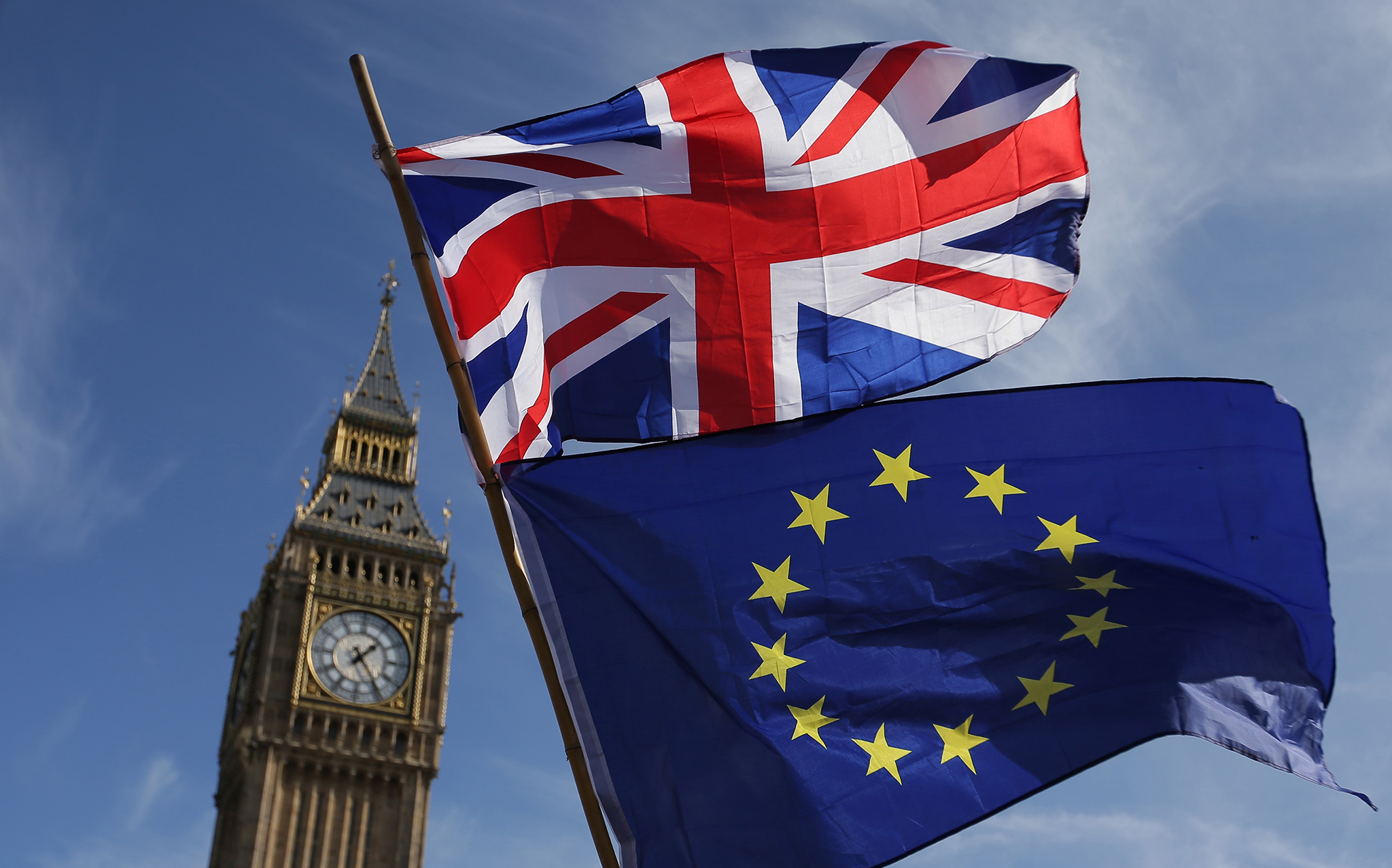 Quốc kỳ Anh (phía trên) và cờ Liên minh châu Âu (EU) phía dưới bên ngoài tòa nhà Quốc hội Anh ở London. Ảnh: AFP/TTXVN
