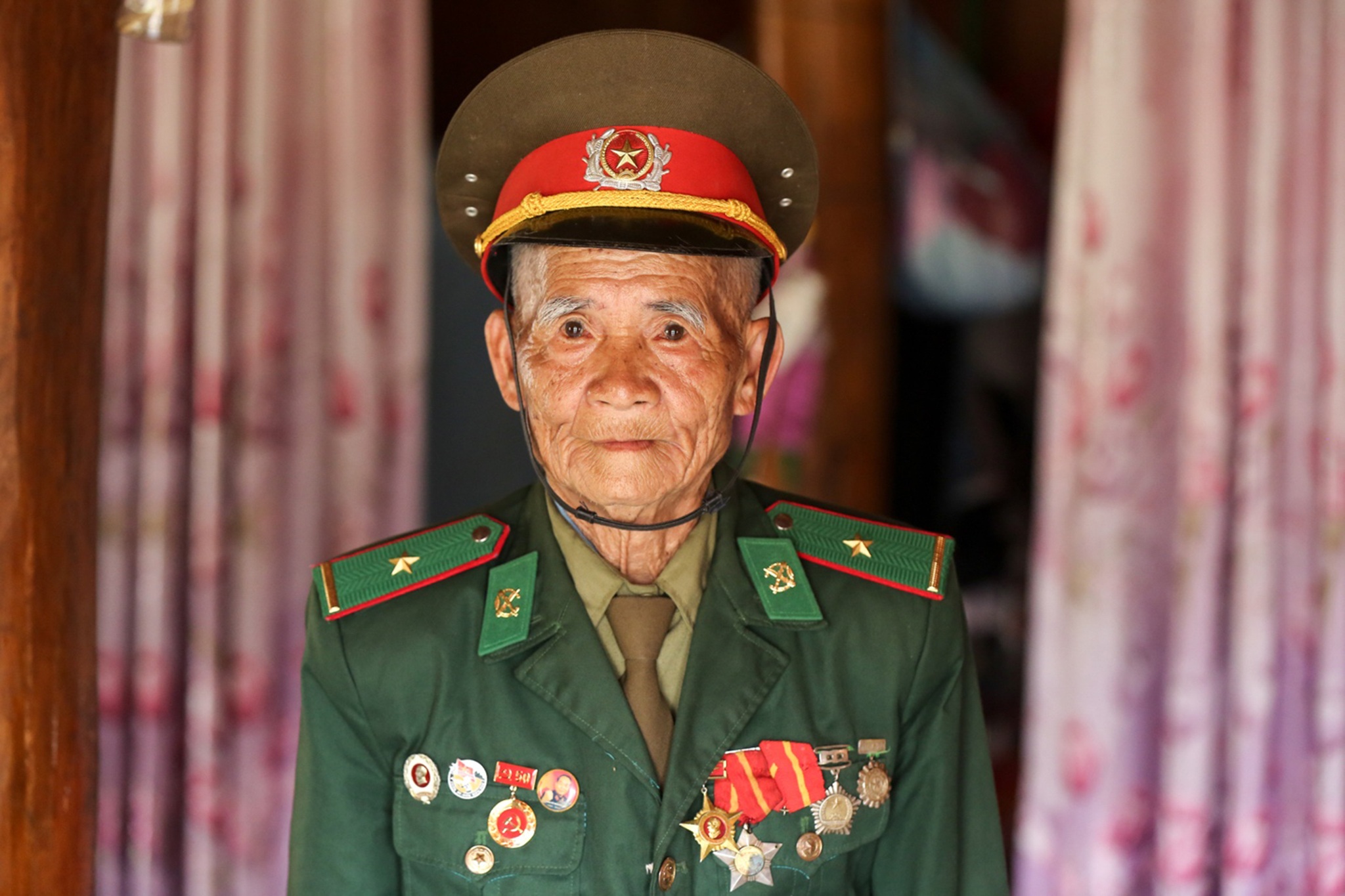 Sau hàng chục năm, ông Păn vẫn giữa lại cho mình bộ quân phục và những chiếc huy hiệu quý giá của một thời hoa lửa. (Ảnh: Lê Minh Sơn/Vietnam+)