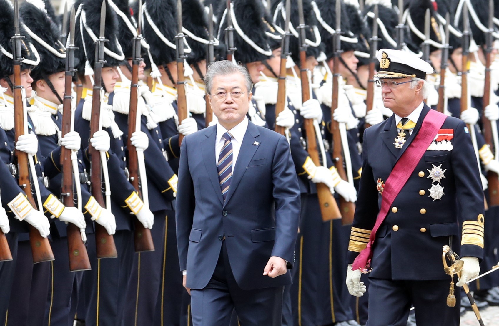 Nhà Vua Thụy Điển Carl XVI Gustaf (phải) và Tổng thống Hàn Quốc Moon Jae-in duyệt đội danh dự tại lễ đón ở Stockholm ngày 14/6. (Ảnh: YONHAP/TTXVN)
