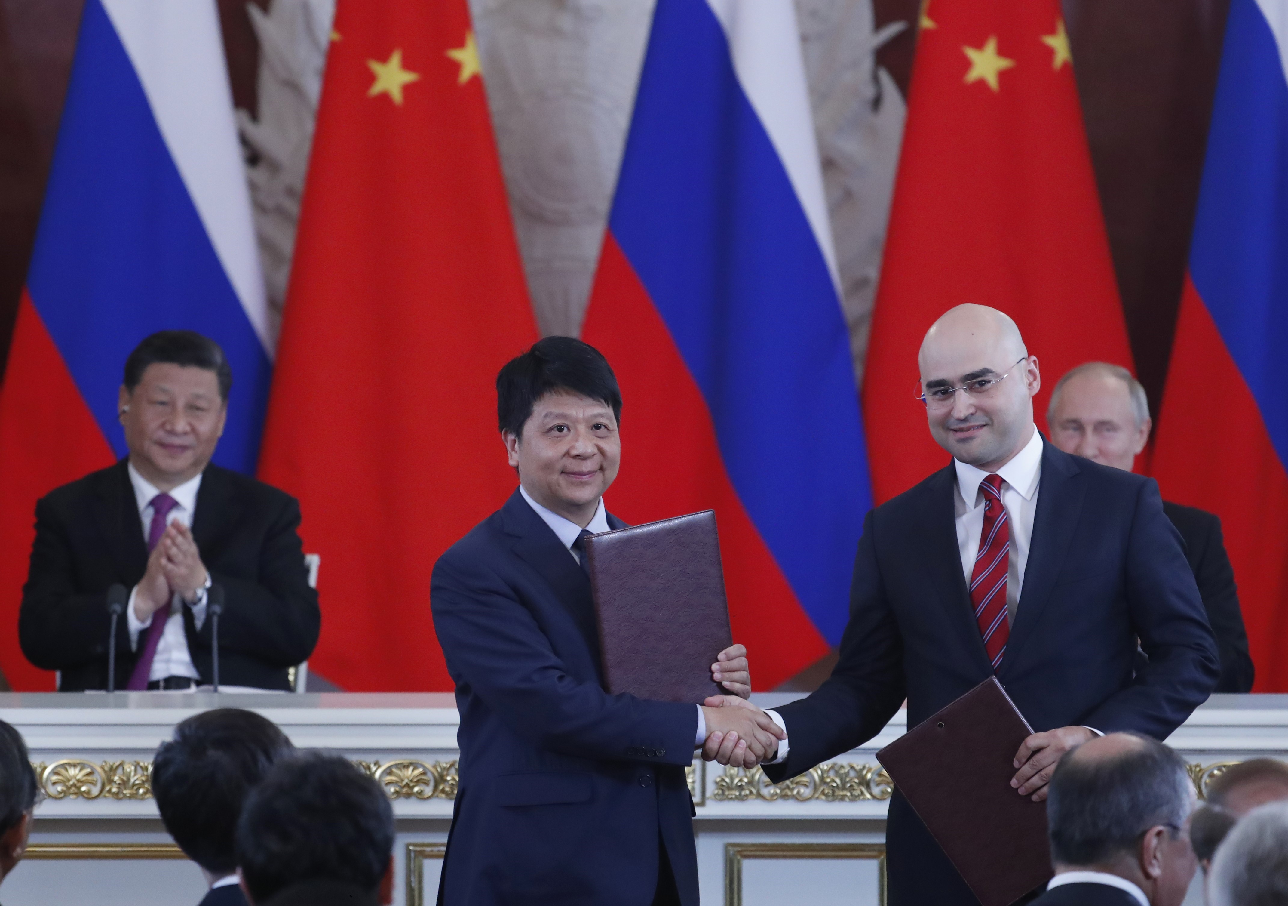 Tổng thống Nga Vladimir Putin (phải) và Chủ tịch Trung Quốc Tập Cận Bình (trái) chứng kiến lễ ký thỏa thuận hợp tác giữa Chủ tịch kiêm Giám đốc điều hành MTS Alexei Kornya (thứ 2, phải) và Chủ tịch luân phiên Huawei Quách Bình (thứ 2, trái) tại Moskva, ngày 5/6/2019. (Nguồn: AFP/TTXVN)