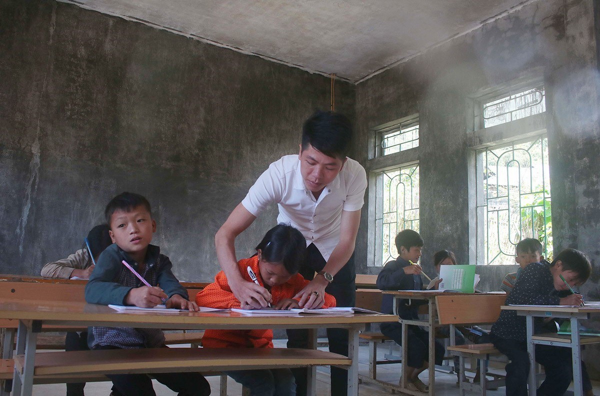 Giáo viên tận tuỵ dạy trẻ tập viết ở điểm trường nhỏ lẻ vùng sâu, vùng xa tỉnh Cao Bằng. (Ảnh: Chu Hiệu/TTXVN)