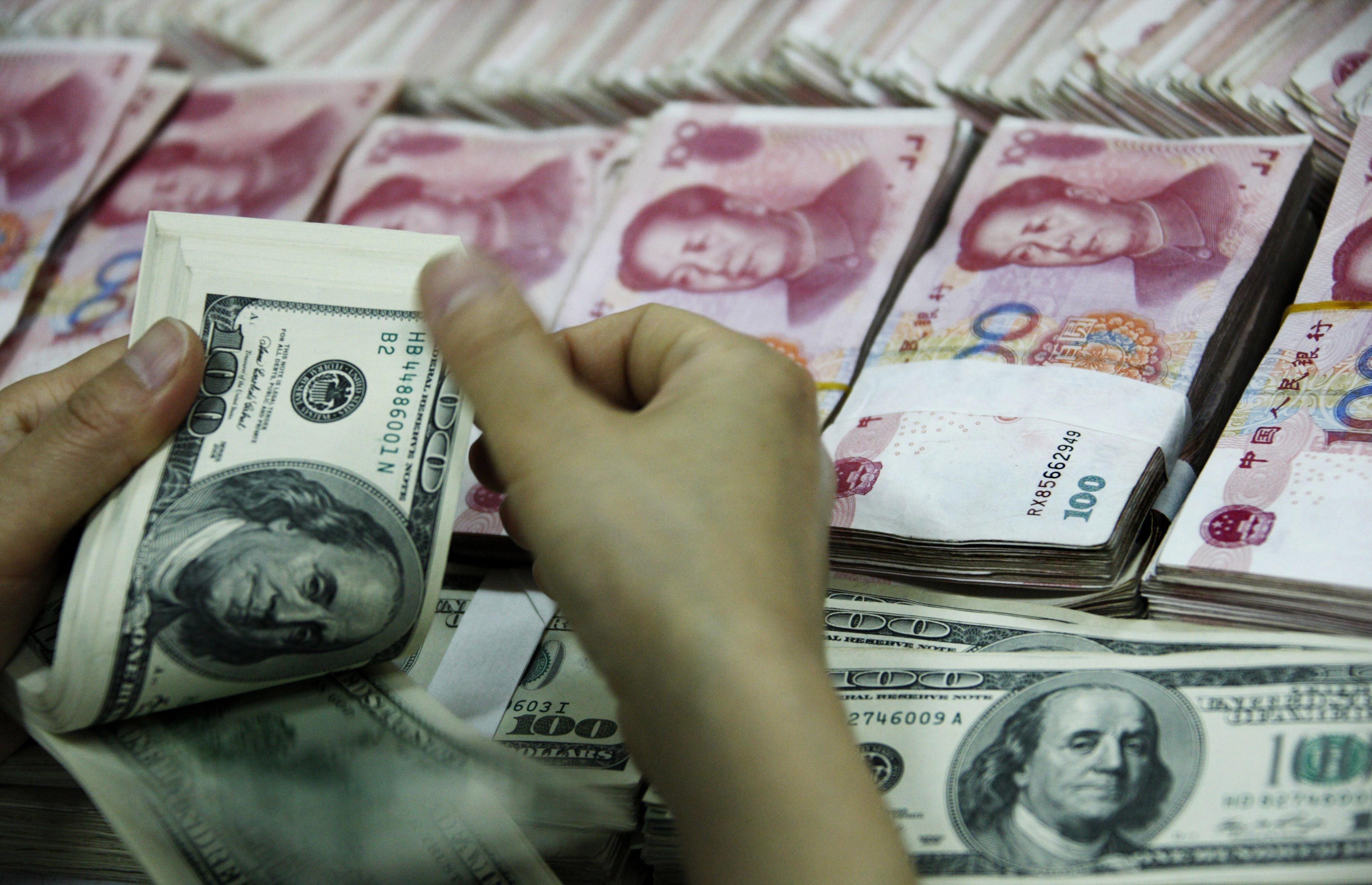 Đồng đôla Mỹ và đồng nhân dân tệ của Trung Quốc tại ngân hàng ở tỉnh An Huy. (Ảnh: AFP/TTXVN)