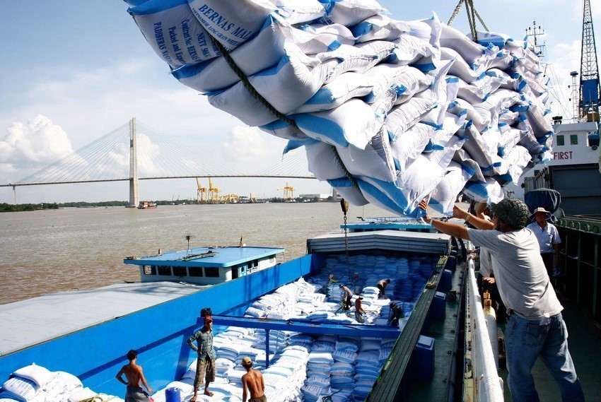 Погрузка и выгрузка риса на экспорт в порту Сайгон. (Фото: Динь Хюэ /ВИА)