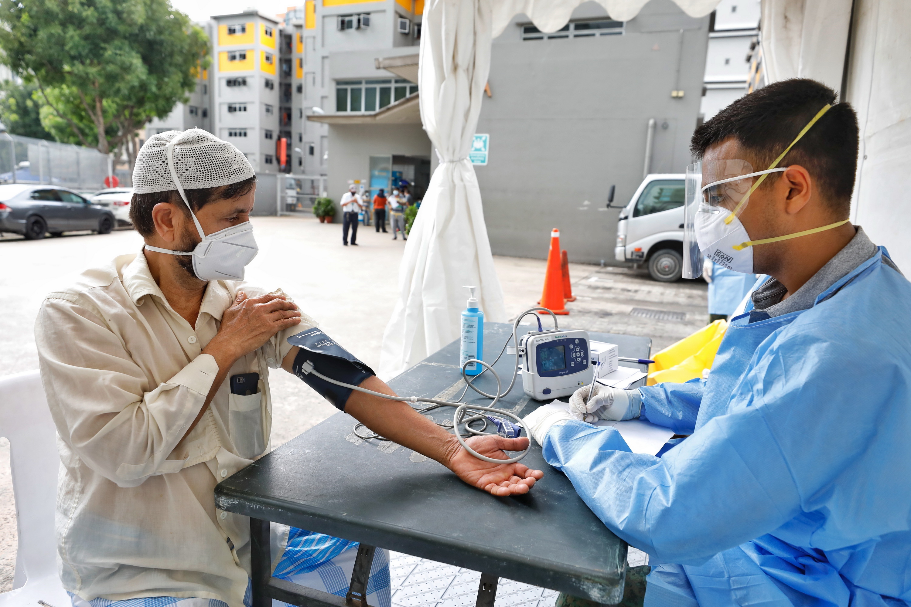 Nhân viên y tế kiểm tra sức khỏe cho người dân tại khu tập thể Toh Guan ở Singapore ngày 8/4/2020 trong bối cảnh dịch COVID-19 lan rộng. (Ảnh: THX/TTXVN)
