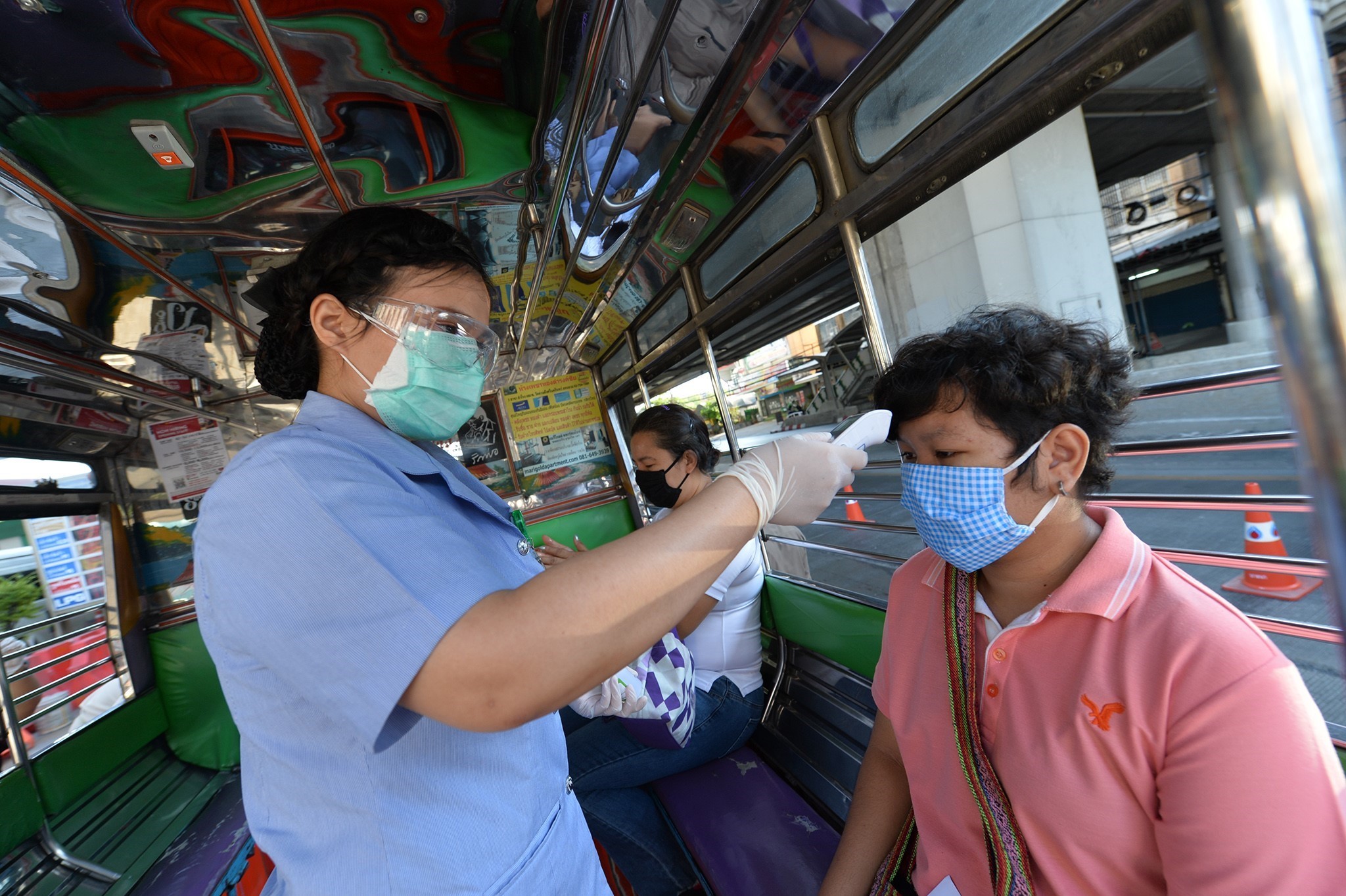 Kiểm tra thân nhiệt cho người dân tại một trạm kiểm soát ở Bangkok, Thái Lan nhằm ngăn chặn sự lây lan của dịch COVID-19, ngày 26/3/2020. (Ảnh: THX/TTXVN)