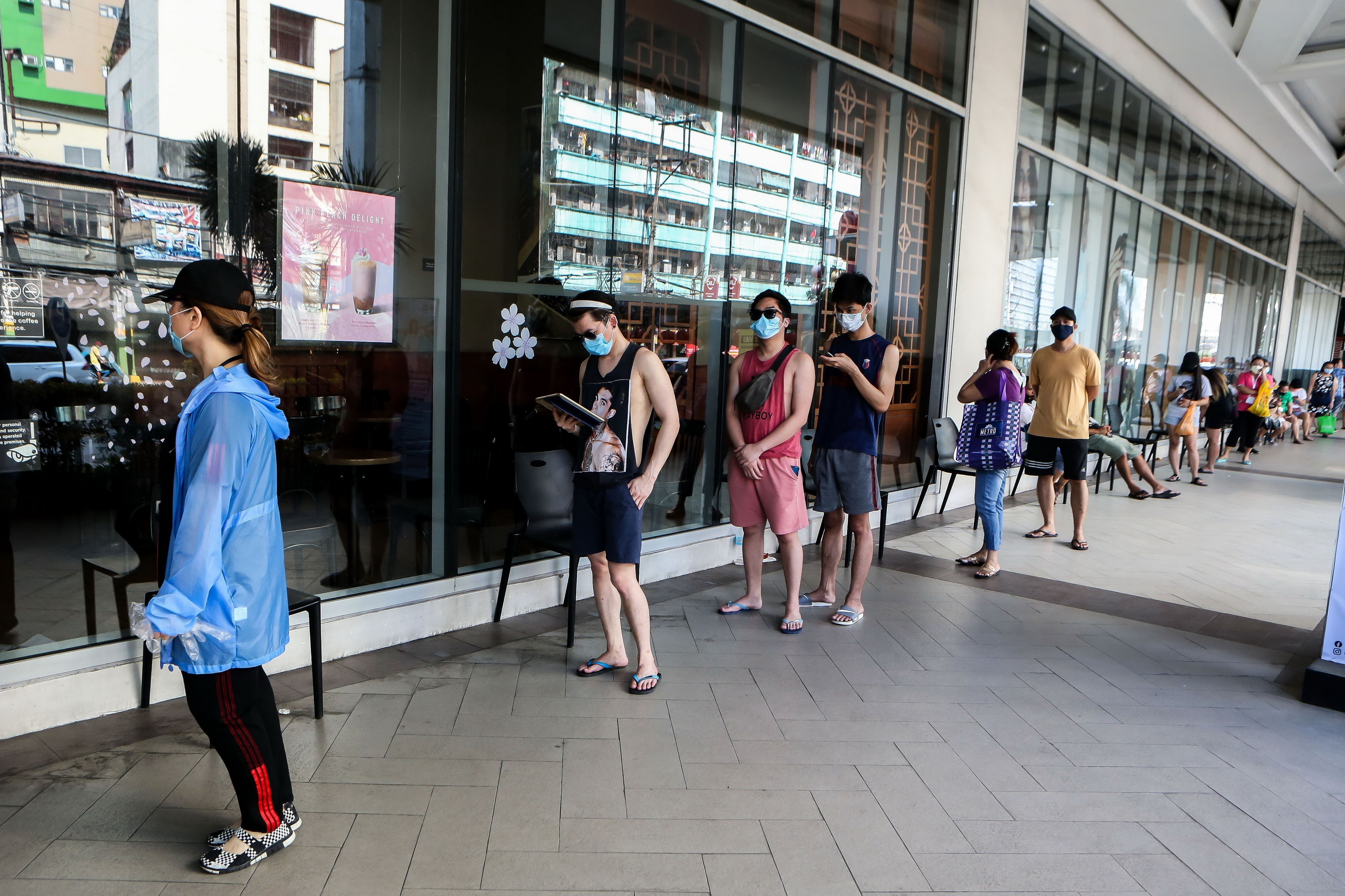  Người dân đeo khẩu trang phòng lây nhiễm COVID-19 khi xếp hàng bên ngoài một cửa hiệu ở Manila, Philippines ngày 11/4/2020. (Ảnh: THX/TTXVN)