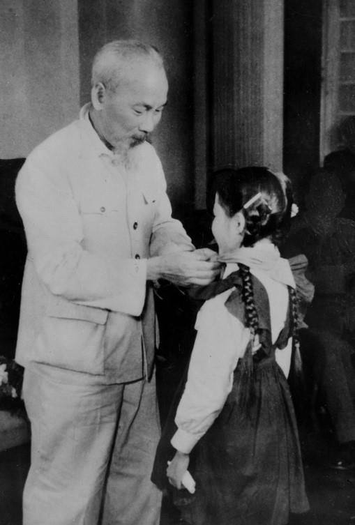  Chủ tịch Hồ Chí Minh quàng khăn đỏ cho đại biểu thiếu nhi Thủ đô đến chúc mừng kỷ niệm 30 năm Ngày thành lập Đảng (1960). (Ảnh: Tư liệu TTXVN)