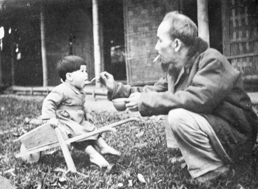 Chủ tịch Hồ Chí Minh bón cơm cho một cháu bé khi đến thăm trại nhi đồng ở chiến khu Việt Bắc (1950). (Ảnh: Tư liệu TTXVN)