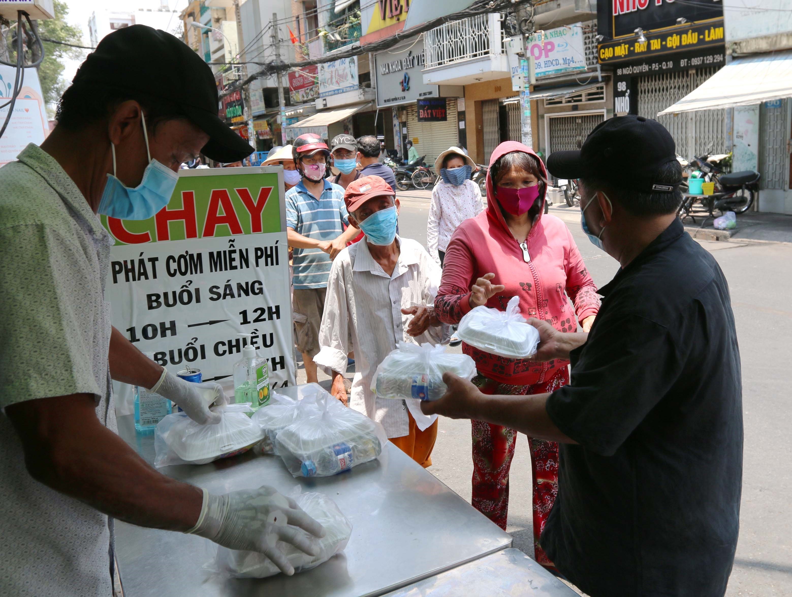 Từng phần cơm miễn phí được trao tận tay người nghèo tại cửa hàng cơm chay Bình An trên đường Ngô Quyền, quận 10 trong mùa dịch COVID-19. (Ảnh: Thanh Vũ/TTXVN)