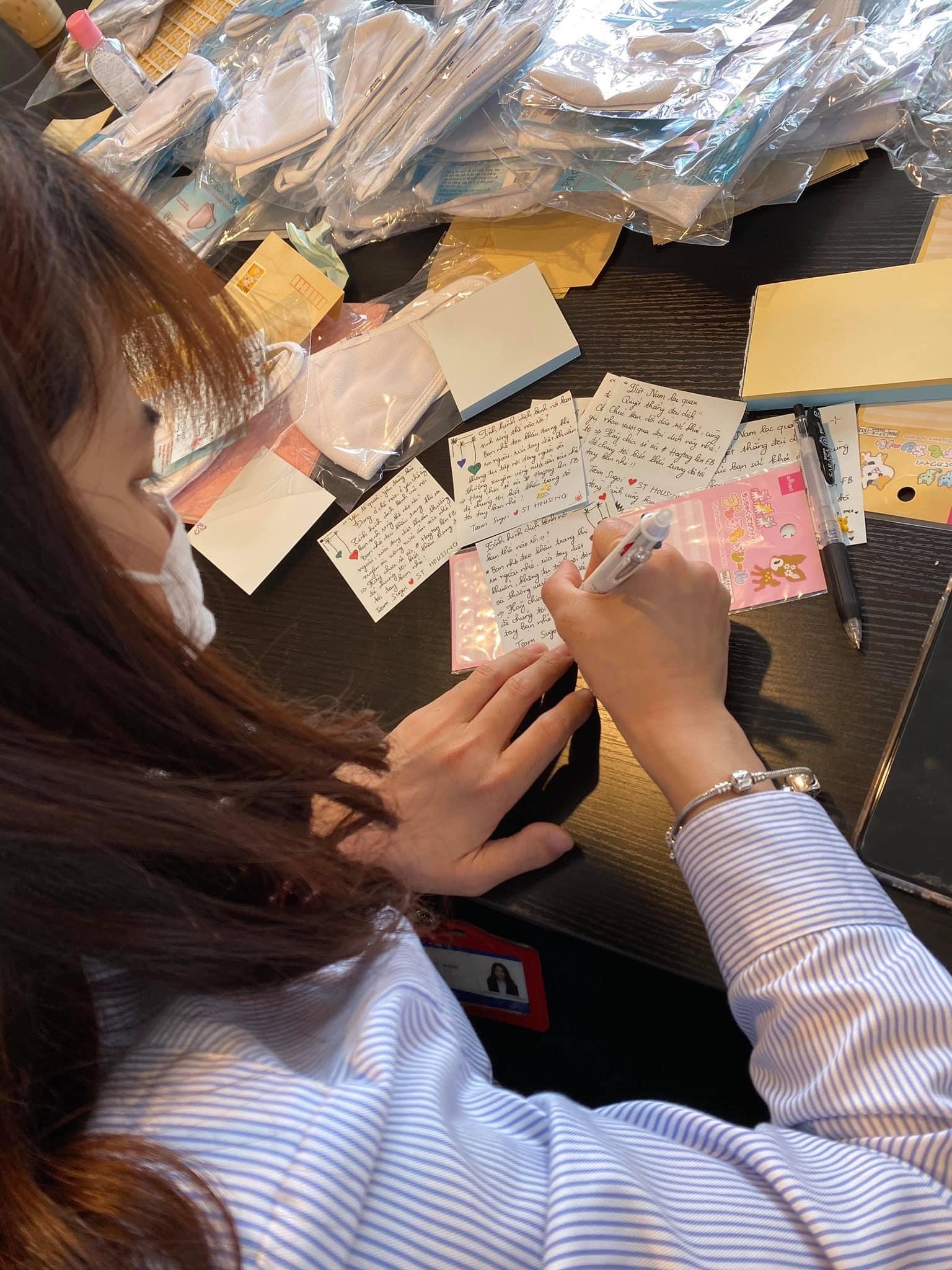 Một thành viên trong nhóm Sugoi đang viết những lời động viên chia sẻ, gửi đến  những bạn mà nhóm tặng khẩu trang.