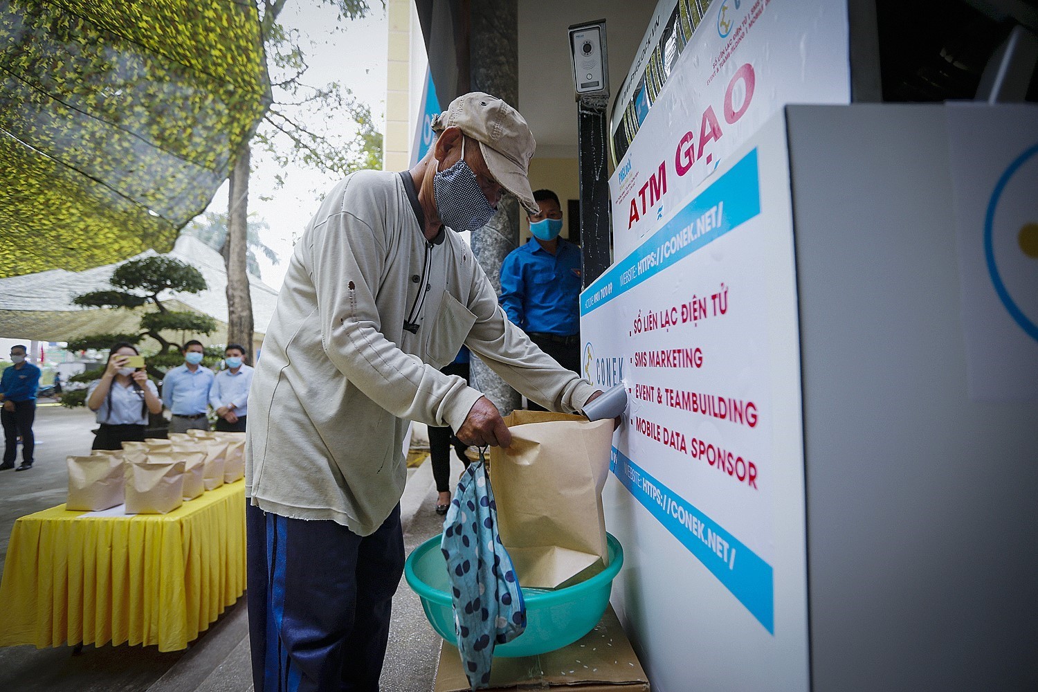 Người dân đến nhận gạo từ cây ATM gạo miễn phí. (Ảnh: Trọng Đạt/TTXVN)