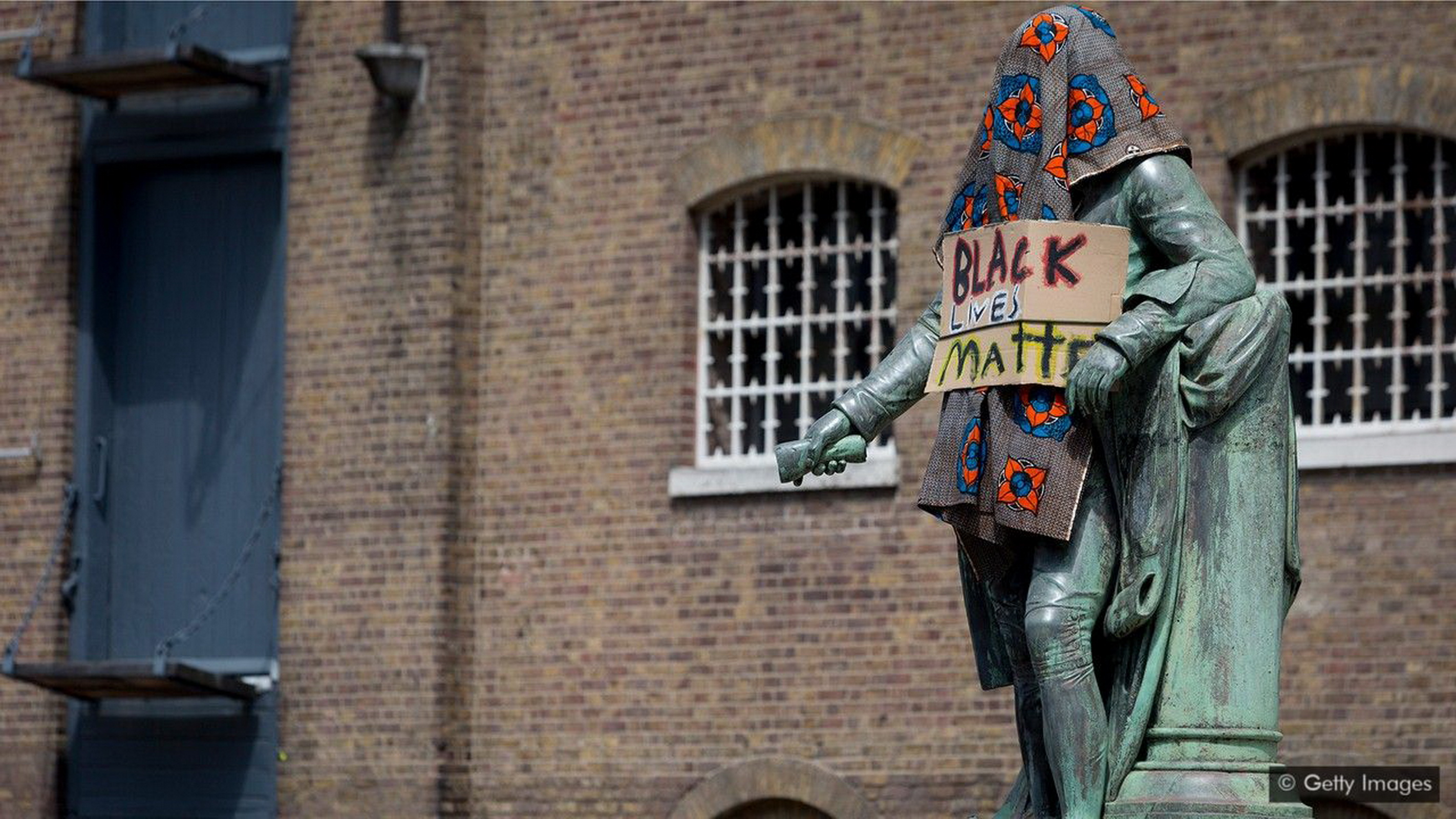Bức tượng thương nhân sở hữu nô lệ Robert Milligan bị các nhà hoạt động của  phong trào Black Lives Matter phủ vải che; bức tượng sau đó đã được tổ chức  Canal and River Trust di dời (Ảnh: Getty Images).