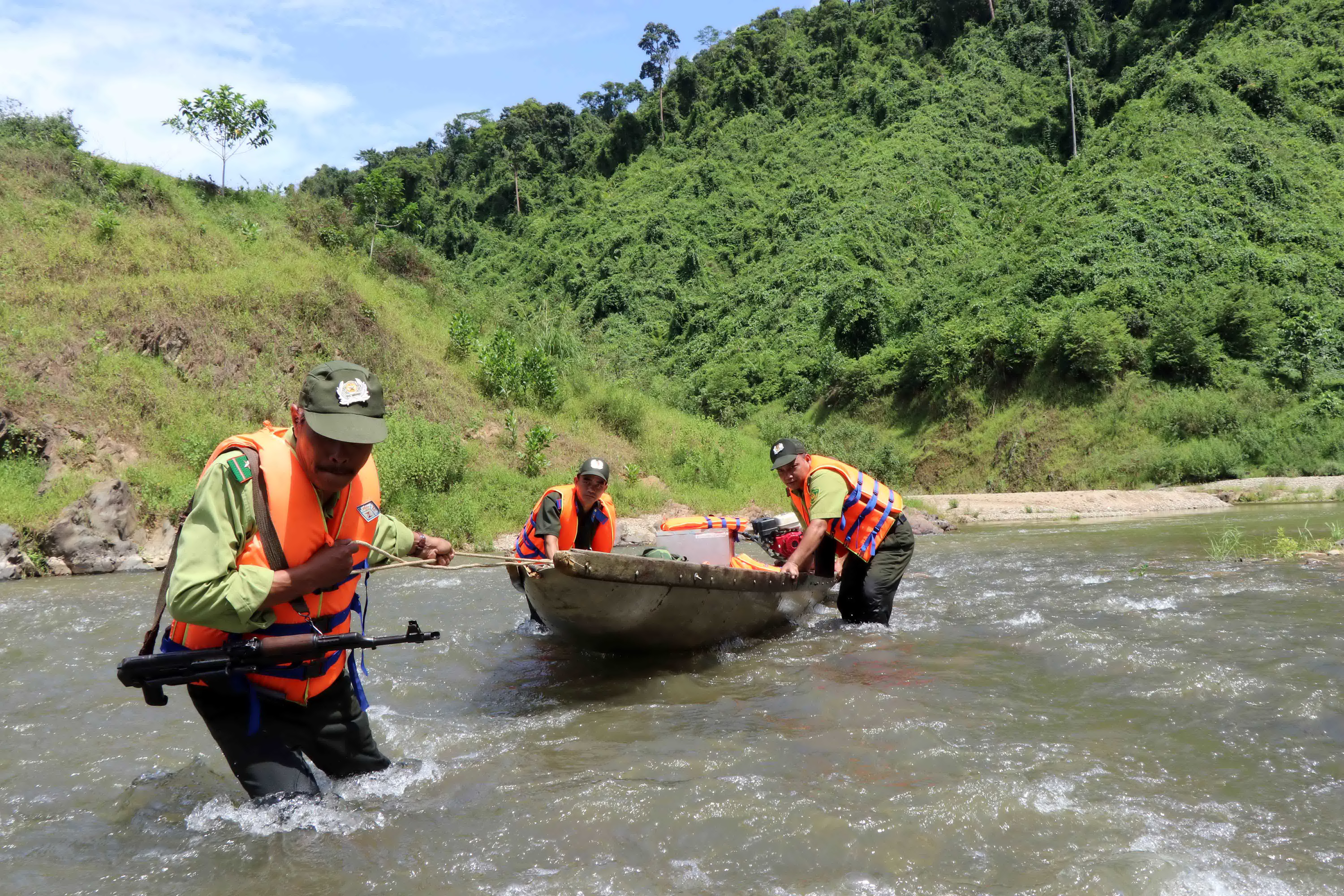 Lực lượng kiểm lâm và bảo vệ rừng chuyên trách tuyến thượng nguồn sông  Hữu Trạch kéo ghe máy ở những đoạn suối cạn nước, trong quá trình đi  tuần tra. (Ảnh: Đỗ Trưởng/TTXVN) 
