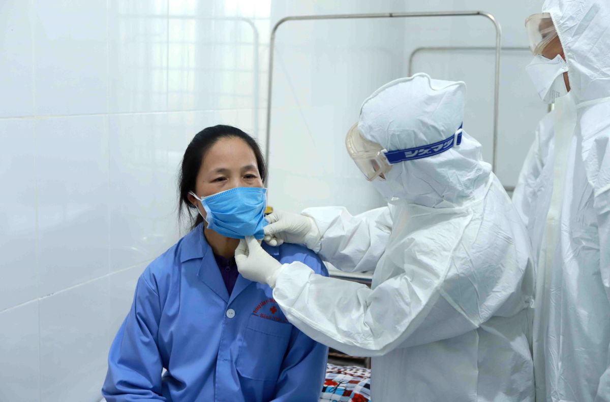 Doctors at Hanoi-based Bach Mai Hospital examine a patient tested positive with the novel coronavirus in Binh Xuyen, Vinh Phuc