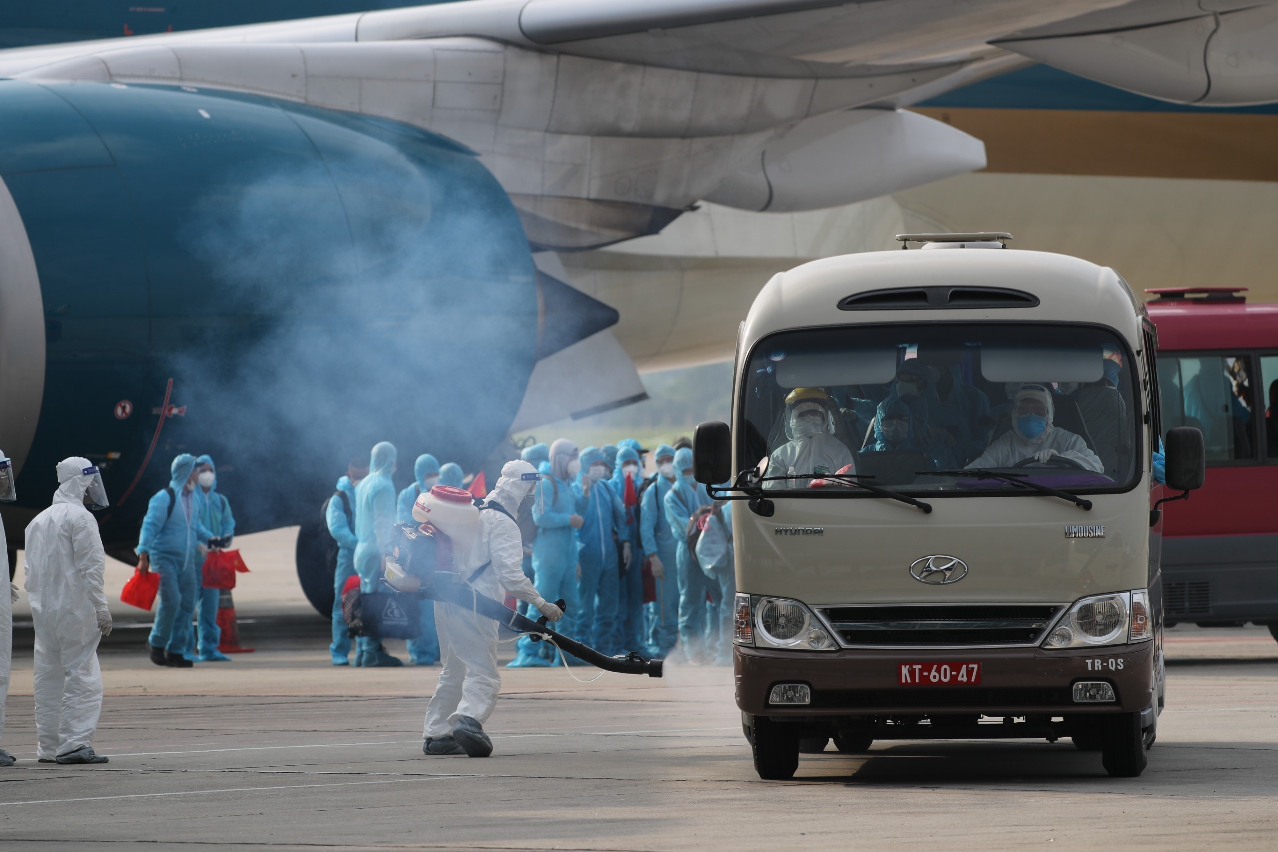 Toàn bộ phương tiện được phun khử khuẩn trước khi rời sân bay đưa công dân về khu cách ly y tế. (Ảnh: Thành Đạt/TTXVN)