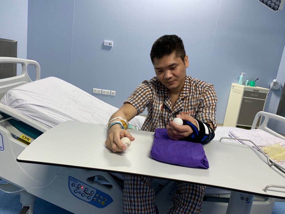 Vuong practises to move his new hand with a ping pong ball (Photo: VietnamPlus)  