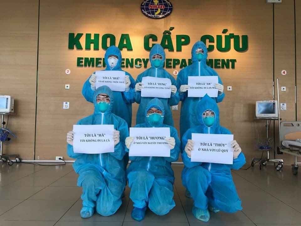 Health workers show messages to people amid the peak of the COVID-19 outbreak (Photo: VietnamPlus)