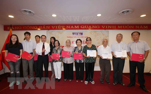Tổng Giám đốc Thông tấn xã Việt Nam Nguyễn Đức Lợi trao sổ tiết kiệm cho các thân nhân gia đình liệt sỹ. (Ảnh: Quý Trung/TTXVN)