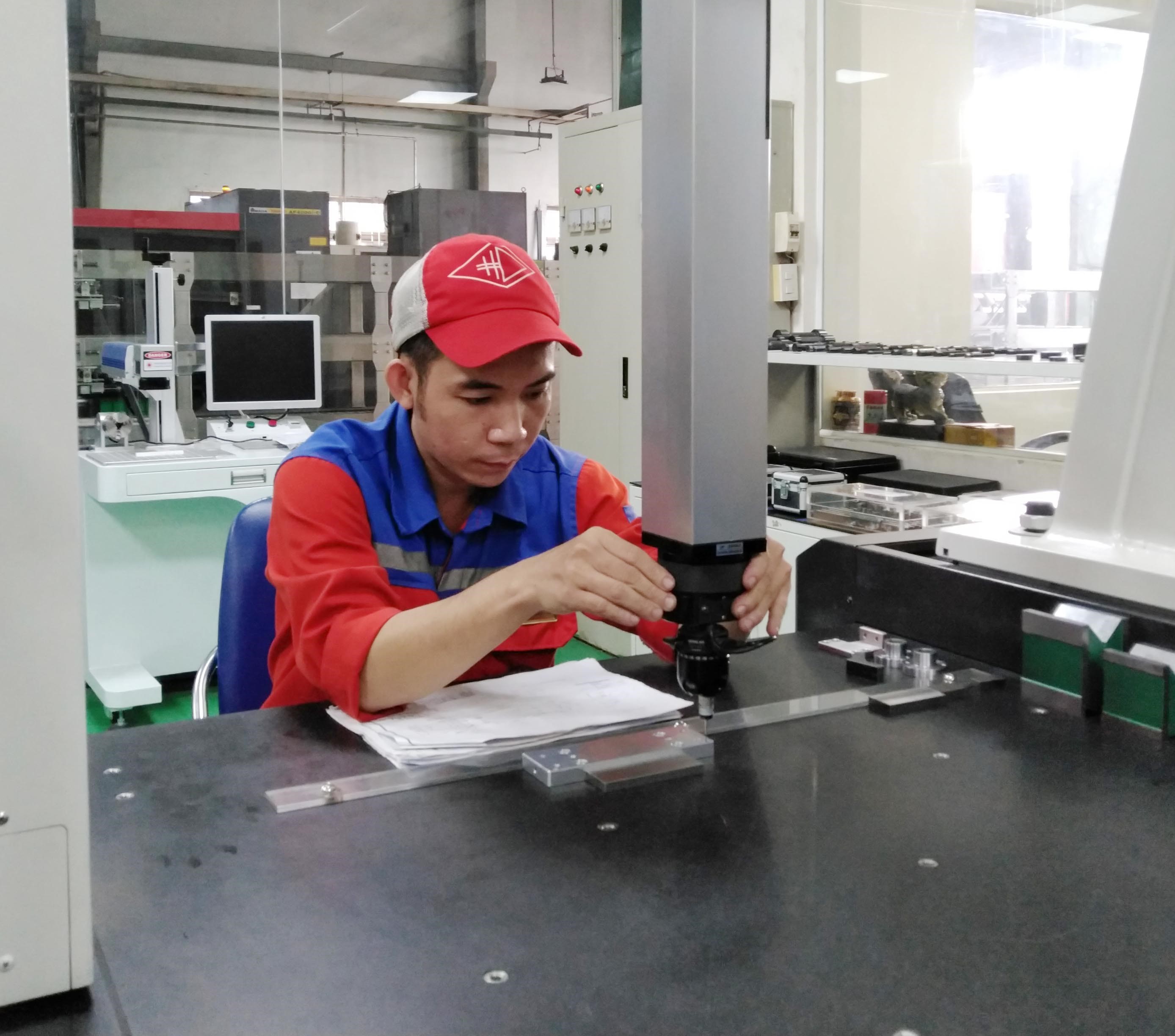 Công nhân nhà máy của công ty Huỳnh Đức tại Đông Nai kiểm tra chi tiết máy đo kỹ thuật cao. (Ảnh: Minh Hưng/TTXVN)