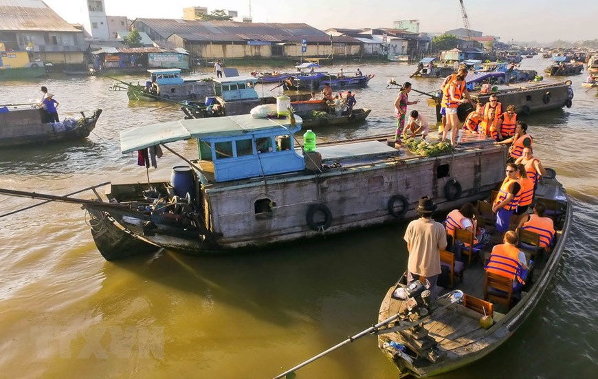 Foreign tourists tour floating stalls at the market (Photo: VNA)