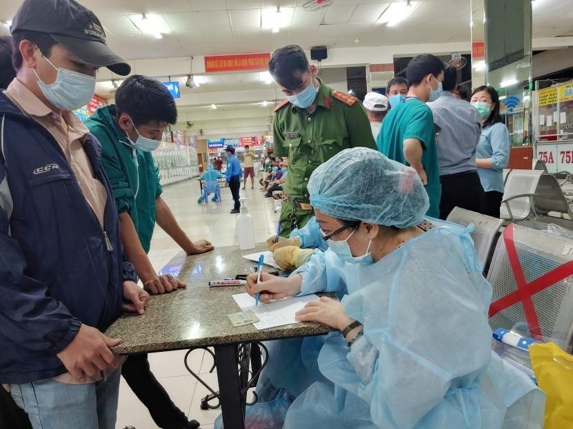 Nhân viên Trung tâm Y tế quận Bình Thạnh chuẩn bị lấy mẫu xét nghiệm tại Bến xe Miền Đông đêm 30 Tết. (Ảnh: TTXVN phát)