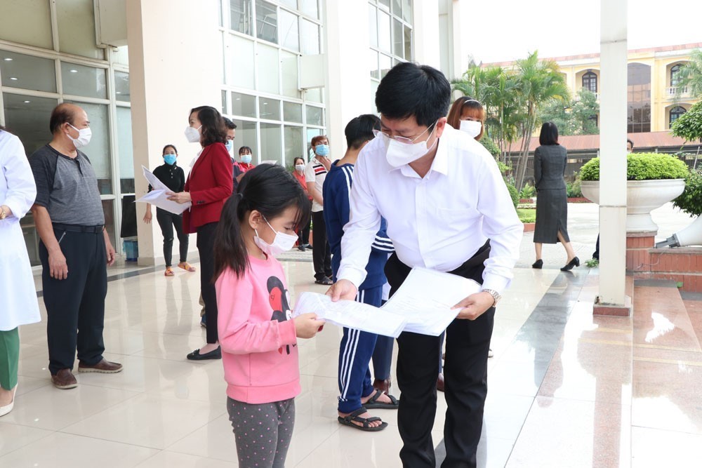 Ông Trần Trọng Khoa, Phó Cục trưởng Cục khám chữa bệnh, Bộ Y tế trao giấy ra viện cho bệnh nhân ra viện. (Ảnh: Mạnh Minh/TTXVN)