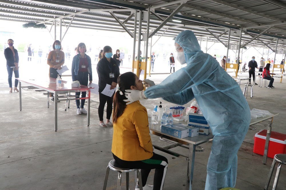 Công nhân ở huyện Gia Lộc, tỉnh Hải Dương được lấy mẫu xét nghiệm trước khi đi làm lại. (Ảnh: Mạnh Minh/TTXVN)