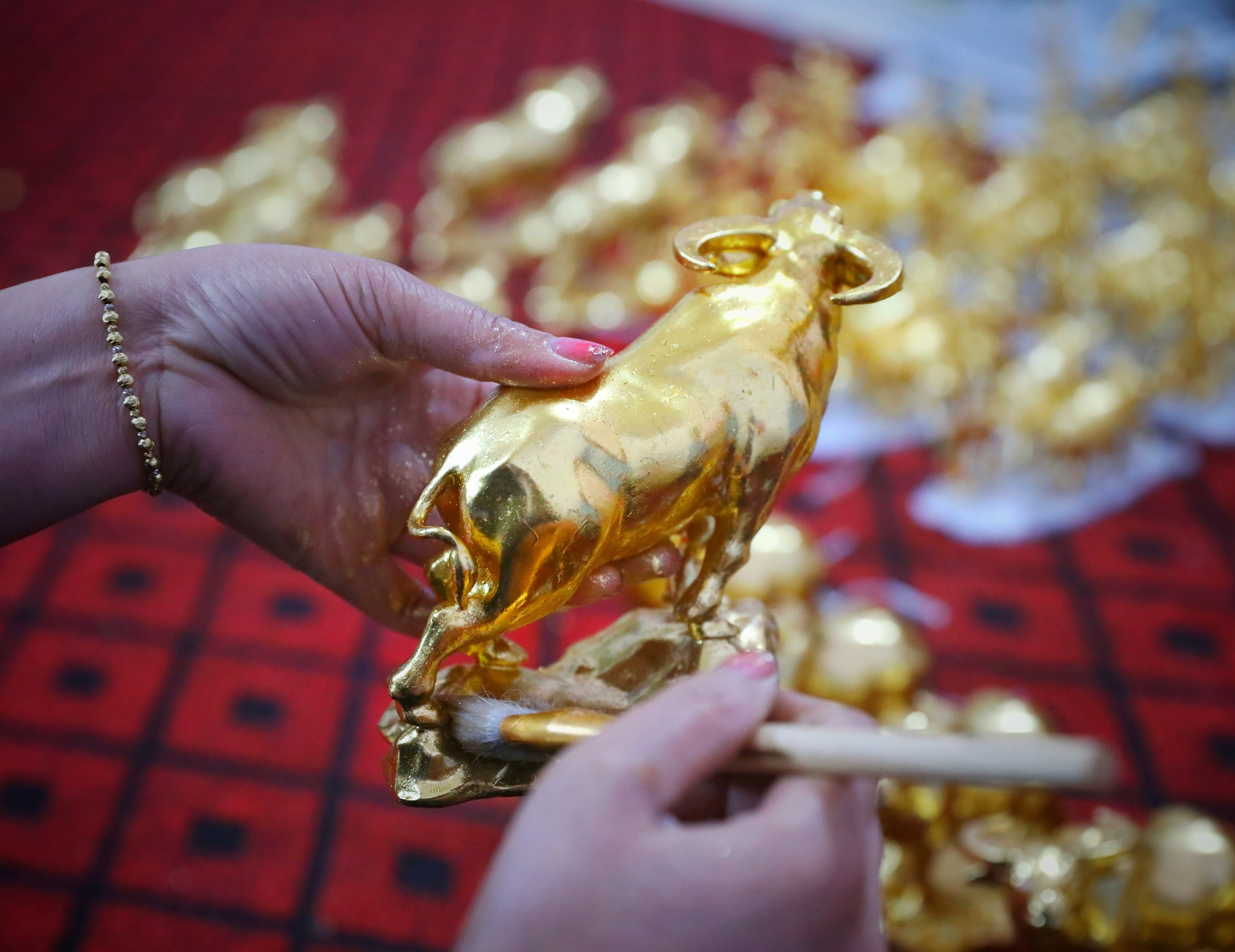 Sản phẩm trâu vàng Tân Sửu 2021 được gia đình nghệ nhân Nguyễn Anh Chung thếp vàng theo đơn đặt hàng. (Ảnh: Danh Lam/TTXVN)