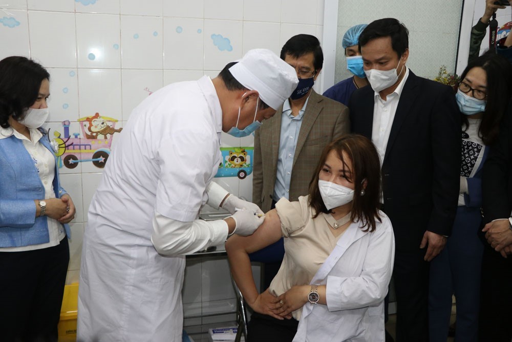 Le vice-ministre de la Santé Do Xuan Tuyen a directement injecté le   vaccin anti-COVID-19 à un agent médical de la province de Hai Duong.   Photo: VNA